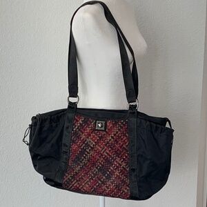 ZEE ALEXIS TRAVEL BAG IN BLACK WITH RED WOVEN FRONT.